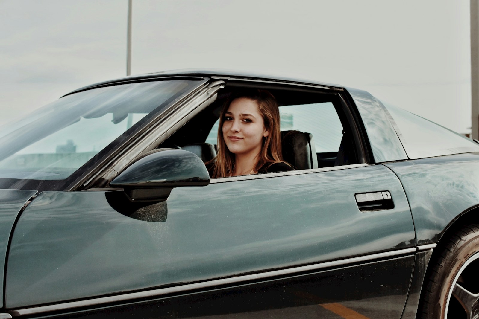 a woman sitting in the drivers seat of a car